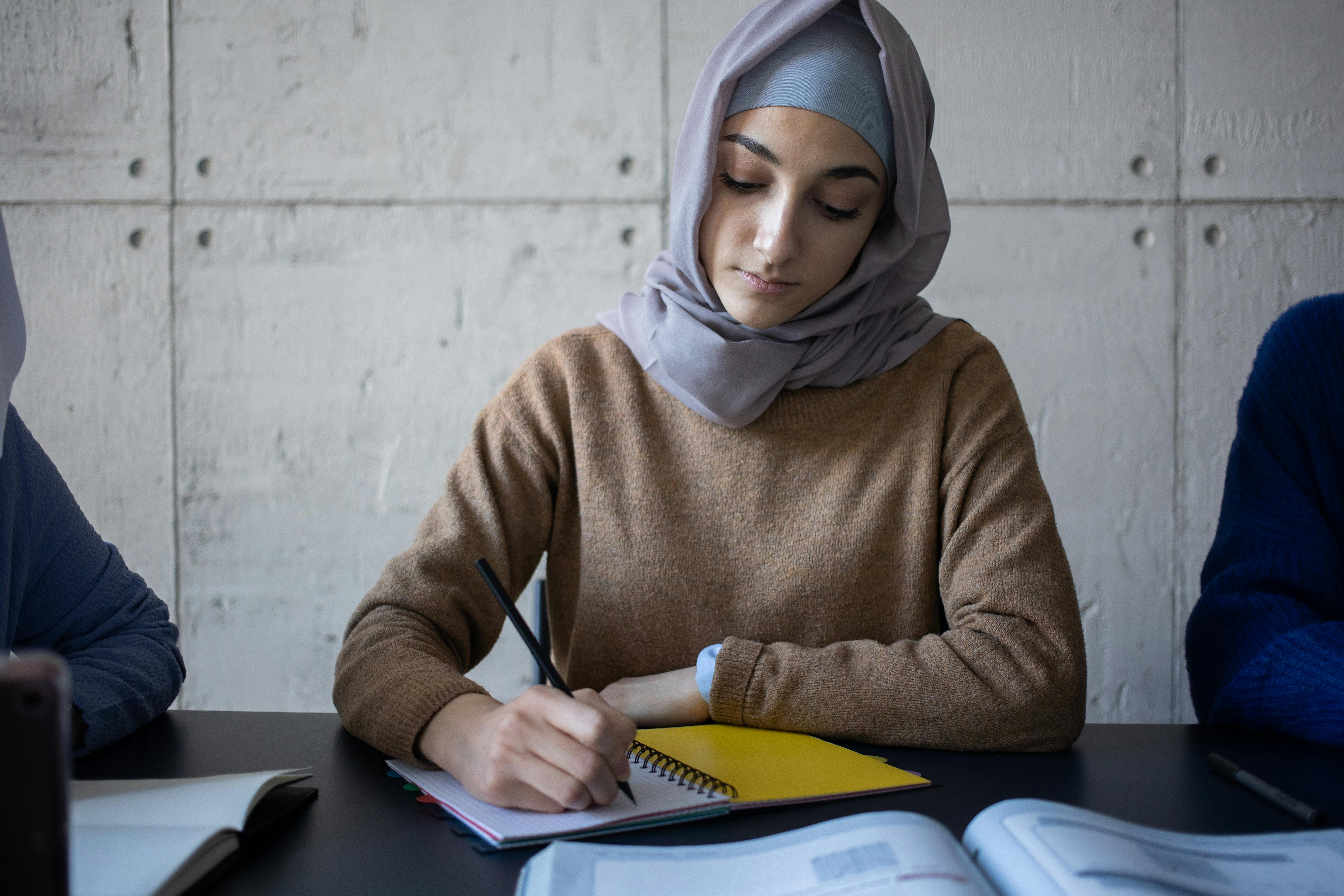 A young woman writing in her notebook